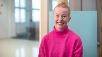 Kuvassa YAMK-opiskelija Jenni Hämäläinen istuu kampuksen käytävälle avautuvan ikkunan edessä.