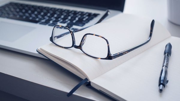 Laptop keyboard, notes and glasses
