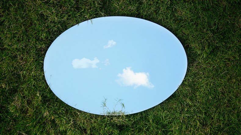 A round mirror on the grass