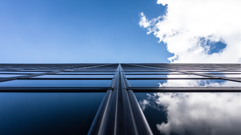 The sky is reflected from the glass wall